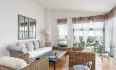 Living area with sofa, armchairs, TV and big panoramic window