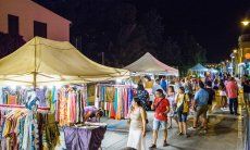 Stand selling colourful cloths on the streetmarket taking place on warm summernights in Golfo Aranci