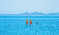 Portobello | Windsurfers on the blue sea in fron of Vignola Mare, about 4 miles from Portobello Vignola Mare - Sport