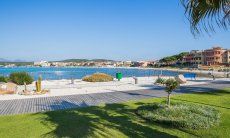 Citybeach with grass and white sand at the harbour of Golfo Aranci