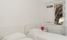 Villa Pola | Bedroom 4 with two single beds and window to the garden Bedroom 4 with two single beds and window to the garden