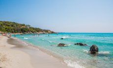 Simius Beach with turqoise shimmering sea and peple bathing in it, 26 km. away 