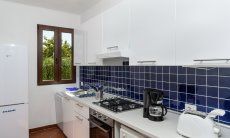 Casa Su Faru 2 | White and blue modern kitchen with oven, gas stove, dishwasher, washing machine and big fride/freezer White and blue modern kitchen in Su Faru 2 Pula
