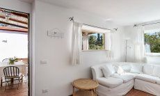 Casa Su Faru 3 | Sofacorner in the living room with garden view and access to the terrace Sofacorner with garden view and access to the terrace of Su Faru 3 Pula