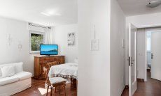 Casa Su Faru 3 | Living room with table, couch, TV and access to two of the bedrooms Living room with table, couch, TV and access to the bedrooms of Su Faru 3 Pula
