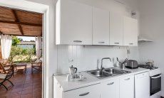 Casa Su Faru 3 | Kitchen with door to the terrace, pratical for eating outside Kitchen with door to the terrace Su Faru 3 Pula