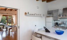 Villa Su Tauloni | Kitchen with view on the dining tables, you chose if inside or outside Villa Su Tauloni, Is Molas, South Sardinia