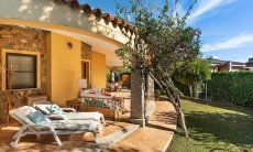 Villa Tiziana 11 | A terrace lines part of the house and boosts comfortable sun loungers, an outside sofa corner and a dining table Portrait of the house