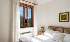 Villa Tiziana 11 | Bedroom 1 with double bed and view into the green nature Portrait of the house