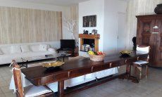 Villa Ulivi 27 | Living room with a big table and fireplace V. Ulivi 27