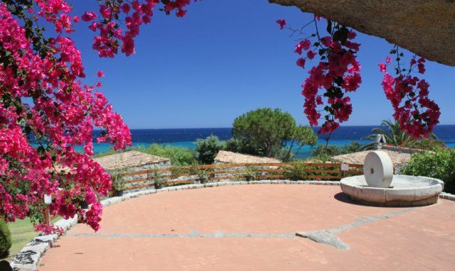 Sant Elmo square with bougainvillea, an old milestone in granite and sea view Sant Elmo square with bougainvillea, an old milestone in granite and sea view